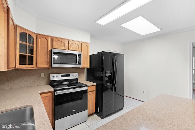 kitchen with decorative backsplash, crown molding, light tile patterned floors, and stainless steel appliances