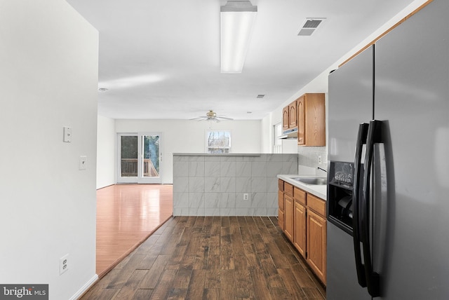 kitchen featuring ceiling fan, stainless steel fridge, sink, and dark wood-type flooring