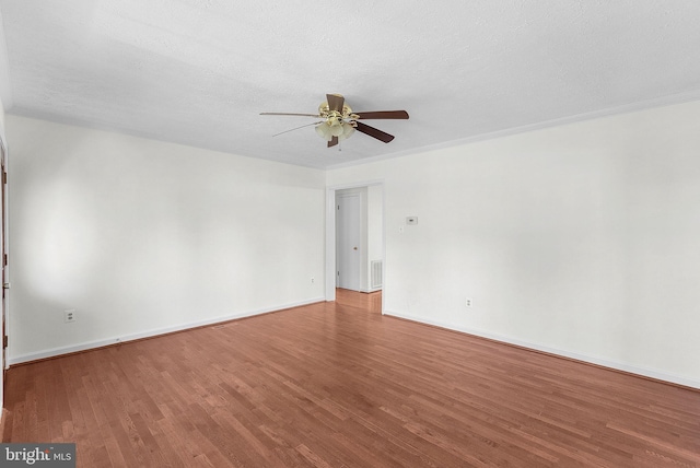 unfurnished room featuring ceiling fan, ornamental molding, a textured ceiling, and hardwood / wood-style flooring