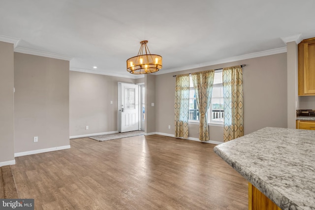 interior space featuring crown molding, light wood-style floors, baseboards, and a chandelier