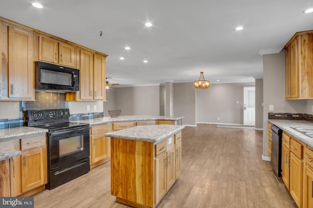 kitchen featuring light hardwood / wood-style floors, a center island, black appliances, and light stone counters