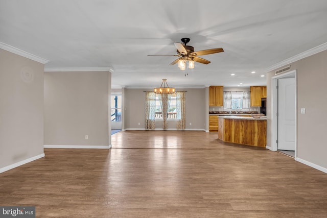 unfurnished living room featuring light hardwood / wood-style floors, ornamental molding, and ceiling fan with notable chandelier