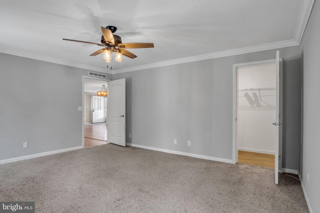 unfurnished bedroom with a spacious closet, visible vents, carpet, and ornamental molding