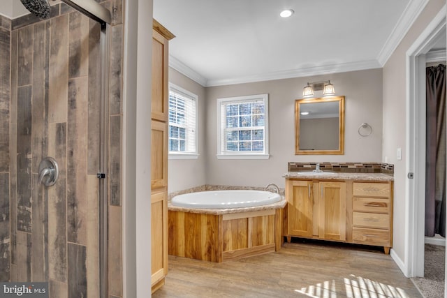 bathroom with crown molding, a stall shower, wood finished floors, a bath, and vanity