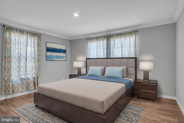 bedroom with wood finished floors, baseboards, and ornamental molding