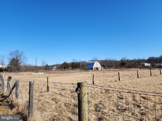 view of yard with a rural view and fence