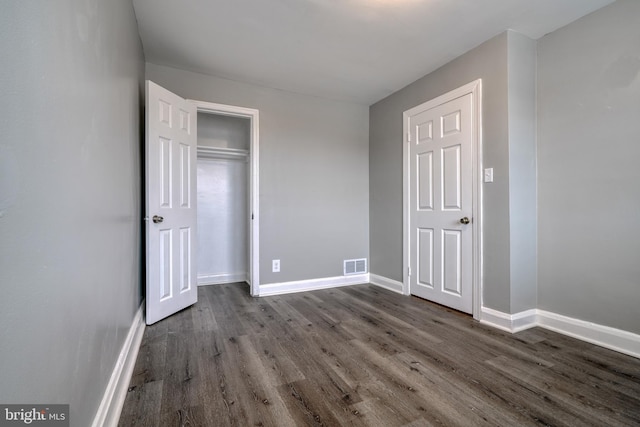 unfurnished bedroom with dark hardwood / wood-style floors