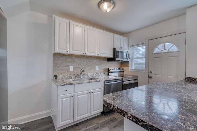 kitchen featuring stainless steel appliances, white cabinetry, sink, and hardwood / wood-style floors