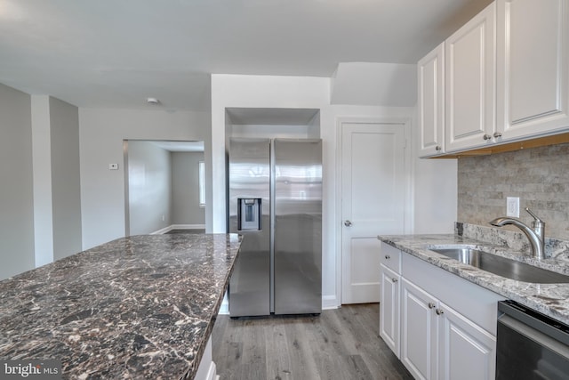 kitchen with dishwasher, sink, white cabinetry, light hardwood / wood-style flooring, and stainless steel fridge