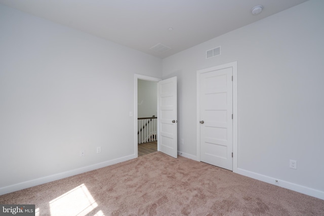 unfurnished bedroom featuring light carpet