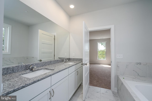 bathroom featuring vanity and tiled tub