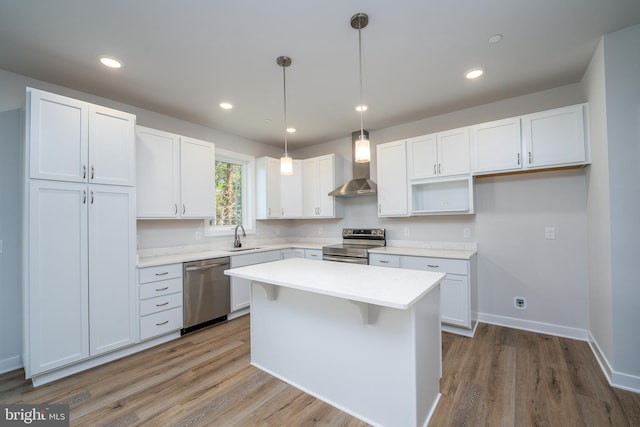 kitchen featuring white cabinets, appliances with stainless steel finishes, and decorative light fixtures