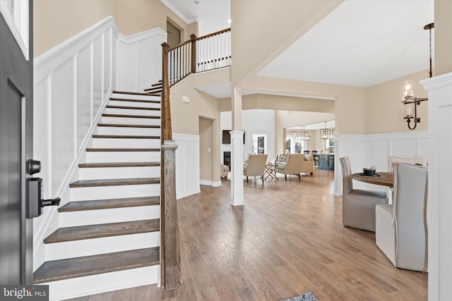 stairs with wood-type flooring and a high ceiling