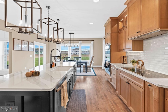 kitchen with a center island with sink, sink, wood-type flooring, and stainless steel appliances