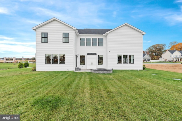 rear view of property featuring a patio area and a lawn