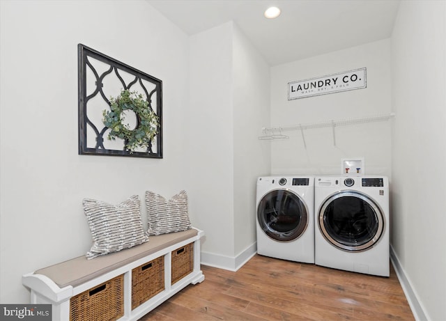 laundry room with washer and dryer and hardwood / wood-style flooring