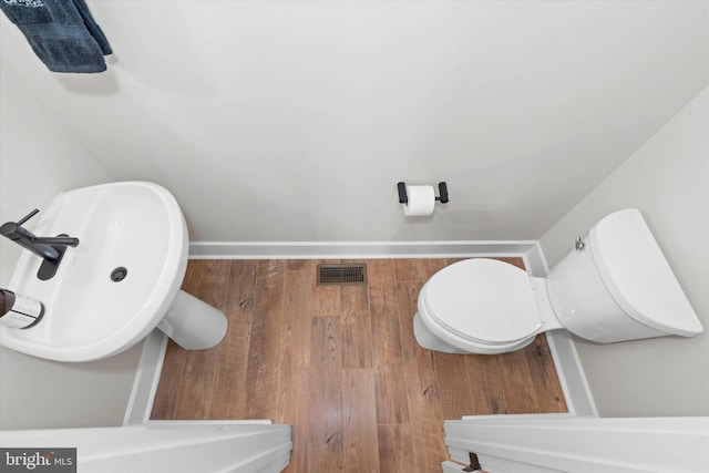 bathroom with sink, hardwood / wood-style flooring, and toilet