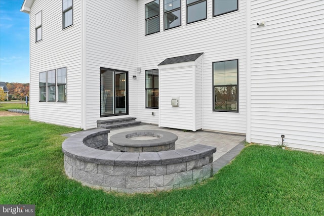 exterior space featuring an outdoor fire pit and a yard