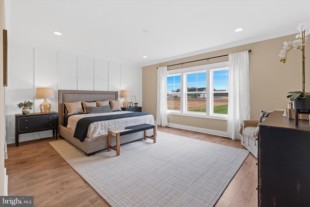 bedroom with crown molding and light hardwood / wood-style flooring