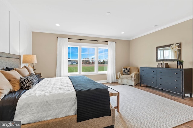 bedroom with crown molding and light hardwood / wood-style floors