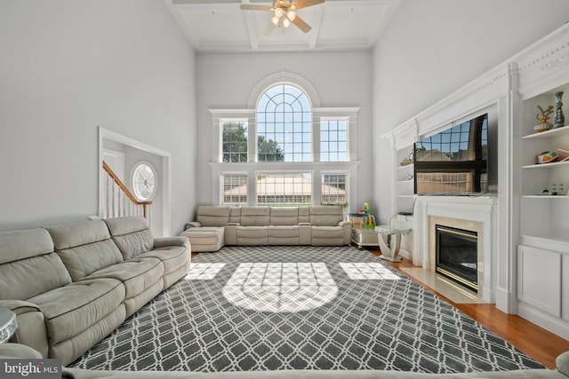 living room with ceiling fan, hardwood / wood-style flooring, and a high ceiling