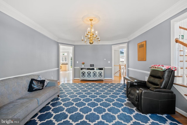 living room featuring hardwood / wood-style flooring, a chandelier, and ornamental molding