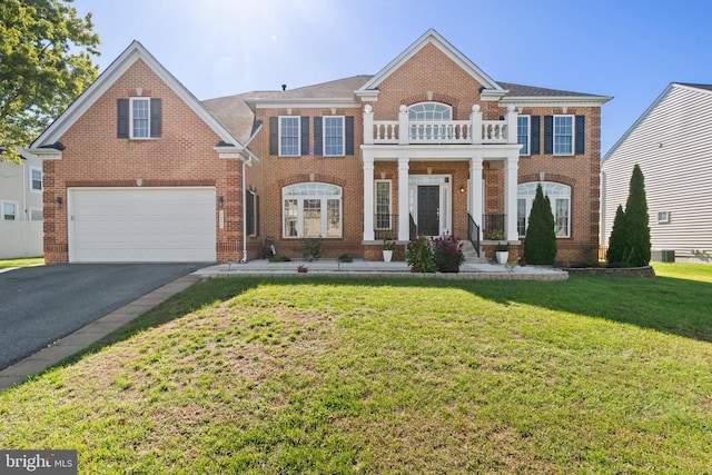 view of front of house with a balcony, a garage, a front yard, and a porch