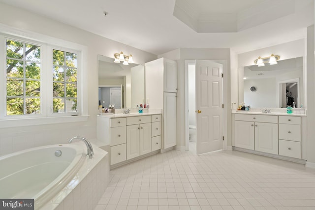 bathroom with tile patterned flooring, vanity, and tiled tub