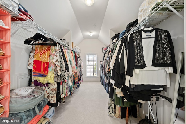 walk in closet featuring light colored carpet and vaulted ceiling