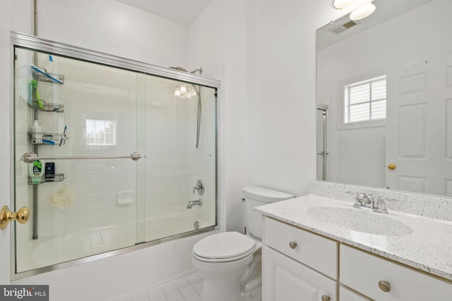 full bathroom with toilet, vanity, bath / shower combo with glass door, and tile patterned floors