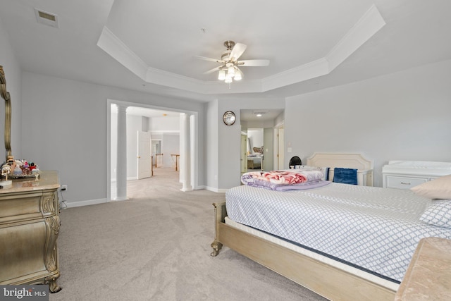 carpeted bedroom with ornate columns, crown molding, ceiling fan, and a raised ceiling