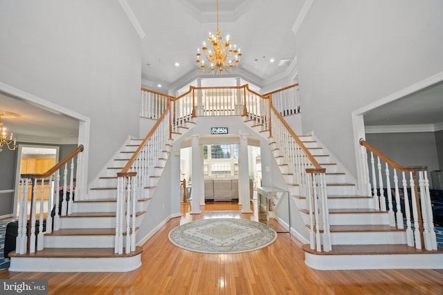 foyer featuring wood-type flooring, a chandelier, and ornamental molding