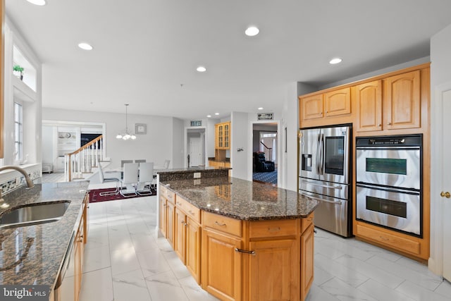 kitchen featuring hanging light fixtures, dark stone countertops, sink, and appliances with stainless steel finishes