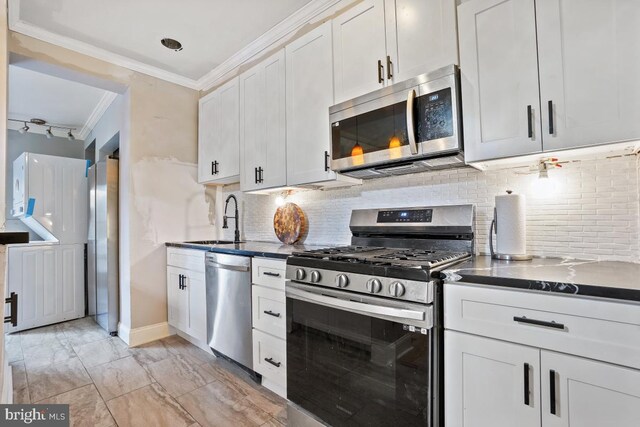 kitchen featuring white cabinets, backsplash, sink, and appliances with stainless steel finishes