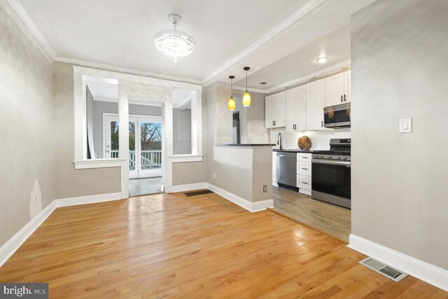 kitchen featuring hanging light fixtures, stainless steel appliances, light wood-type flooring, white cabinets, and ornamental molding