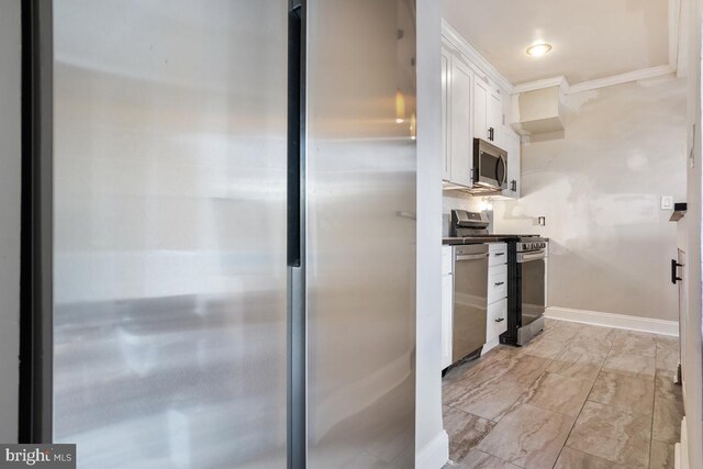 kitchen featuring decorative backsplash, stainless steel appliances, white cabinetry, and ornamental molding