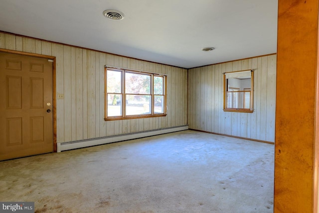 carpeted empty room featuring a baseboard radiator and wood walls