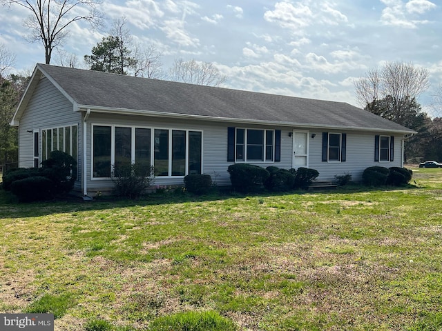 view of front of property with a sunroom and a front lawn