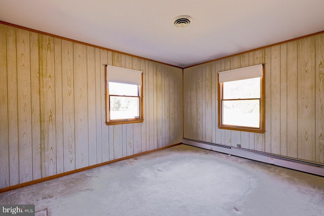 carpeted spare room featuring a baseboard radiator and wood walls