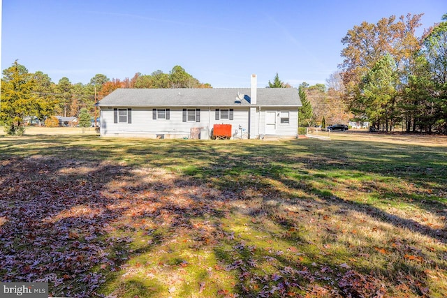 rear view of property with a lawn