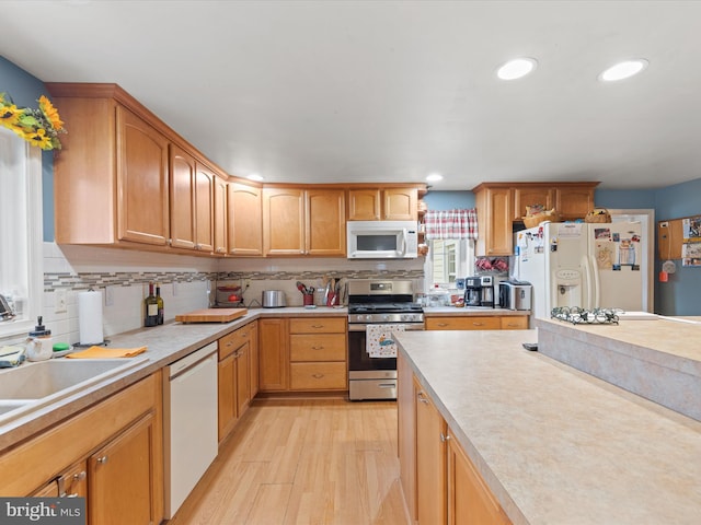 kitchen featuring tasteful backsplash, white appliances, and light hardwood / wood-style flooring