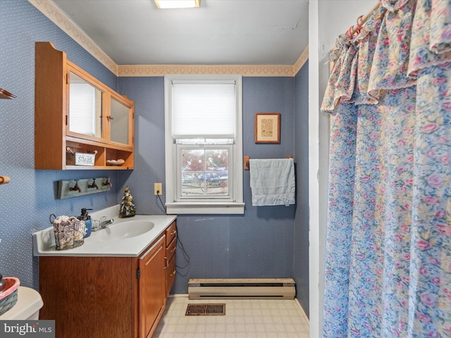 bathroom with baseboard heating, vanity, and toilet