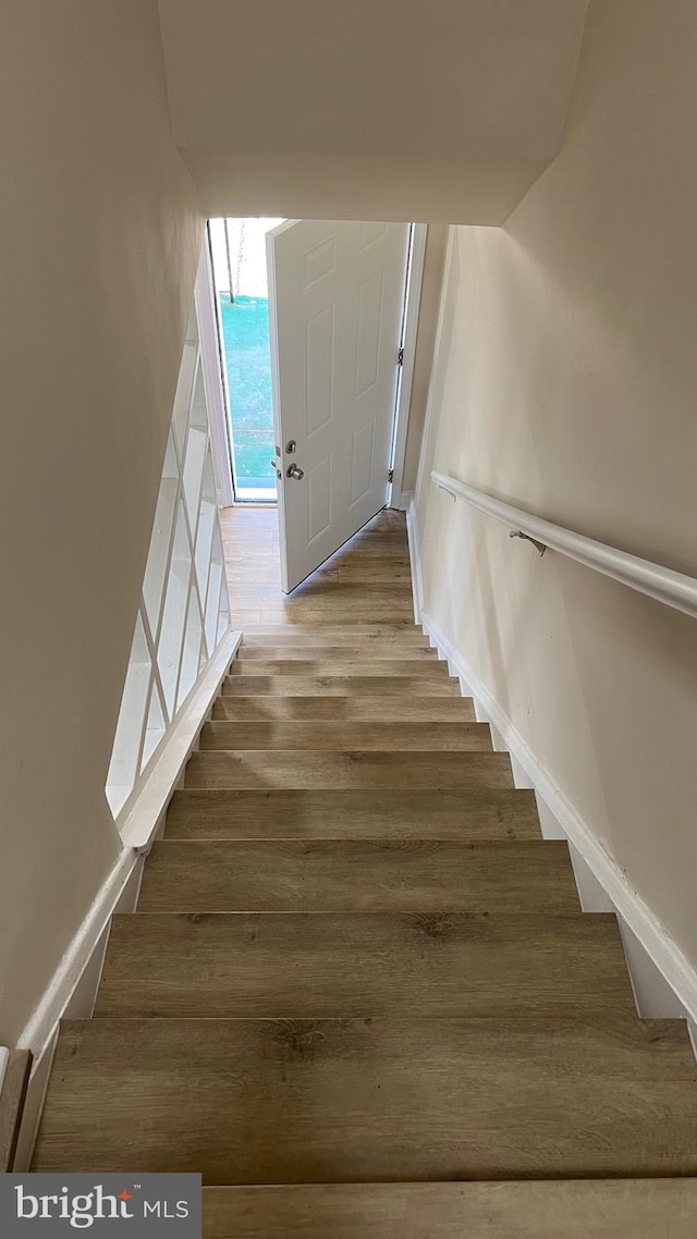 stairs featuring hardwood / wood-style floors