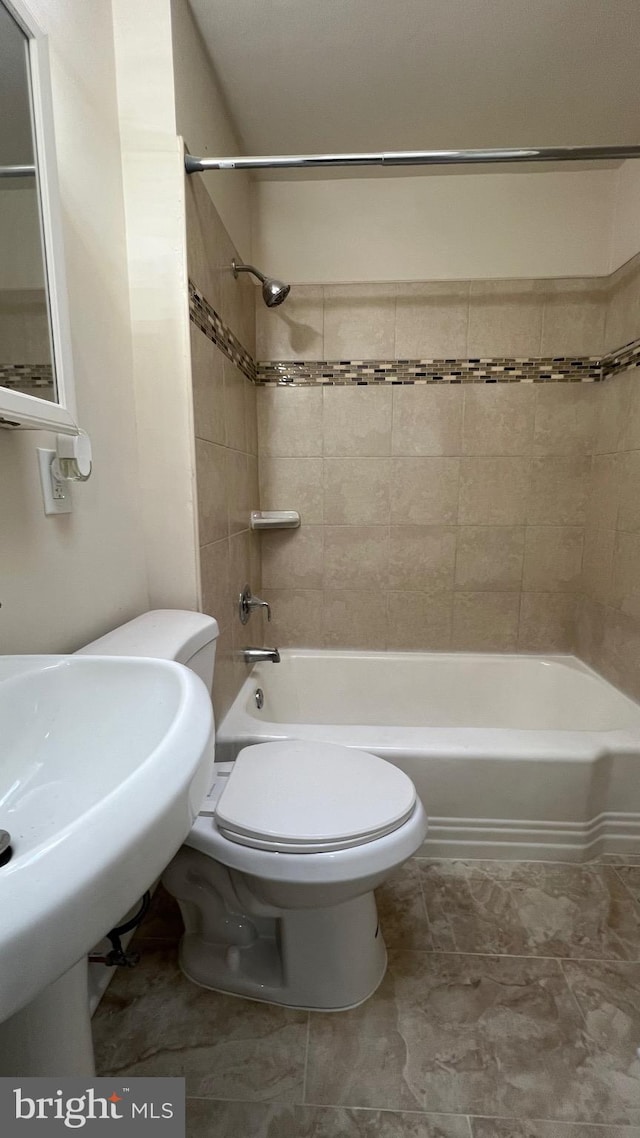 bathroom with tiled shower / bath combo and toilet