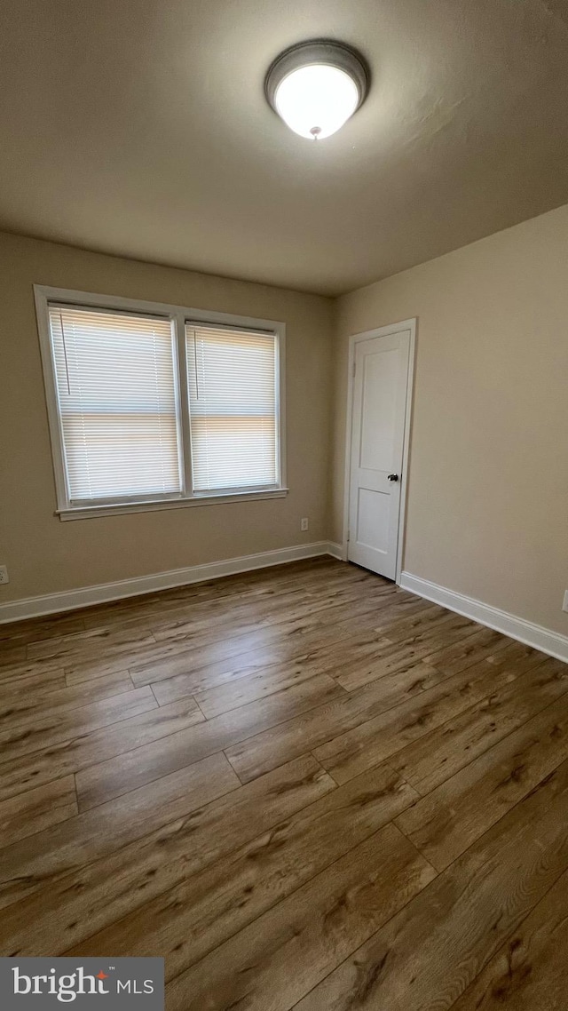 unfurnished room with wood-type flooring