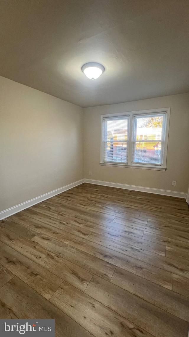 empty room with dark hardwood / wood-style flooring