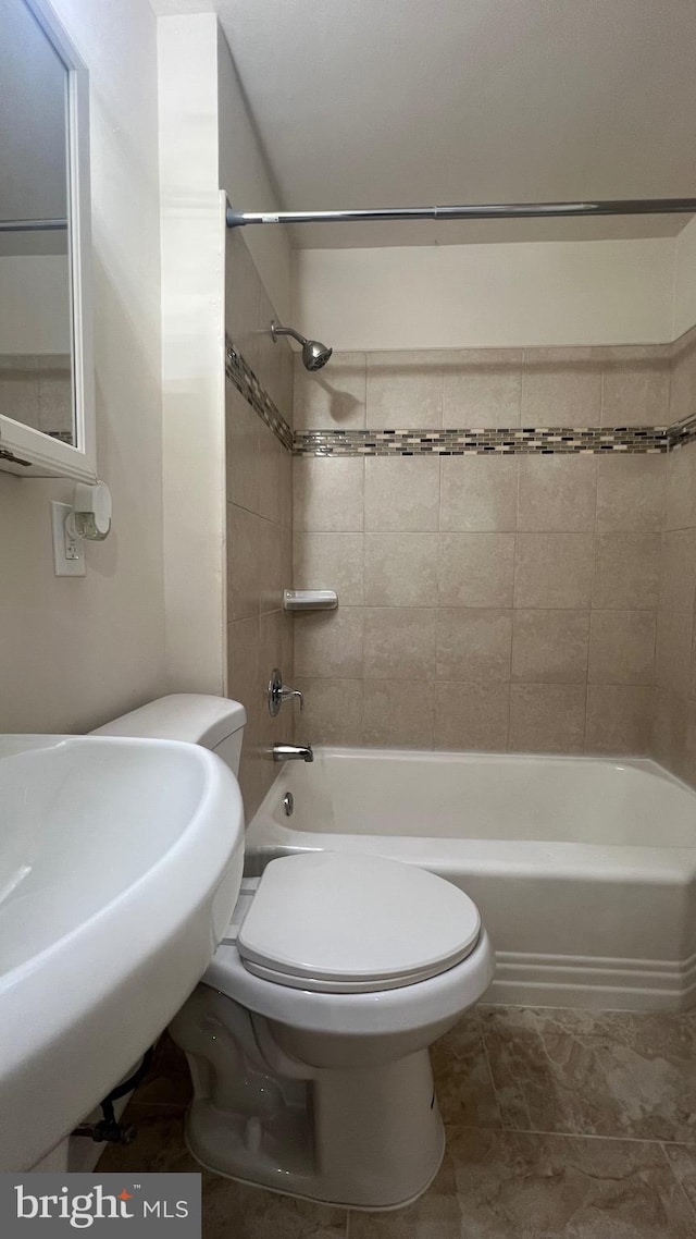 full bathroom featuring sink, tile patterned flooring, tiled shower / bath combo, and toilet