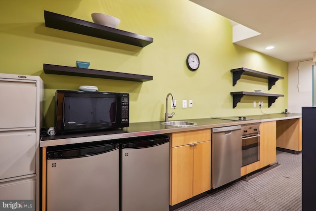 kitchen with appliances with stainless steel finishes, sink, and light carpet