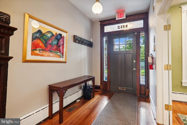 foyer entrance with hardwood / wood-style floors, plenty of natural light, and a baseboard heating unit