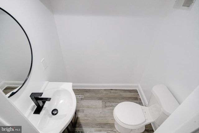 bathroom with toilet and hardwood / wood-style floors